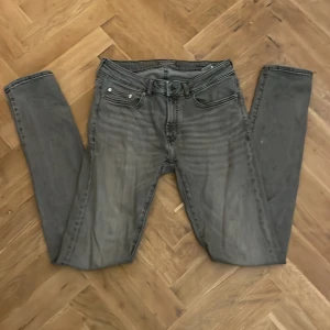 Gråa Jeans - Säljer dessa jättesnygga jeans från Dressmann i färgen grå. Jeansen är i slim fit. W31(37cm) och L34(112cm). Nypris 599kr. Hör av er vid frågor!✌️