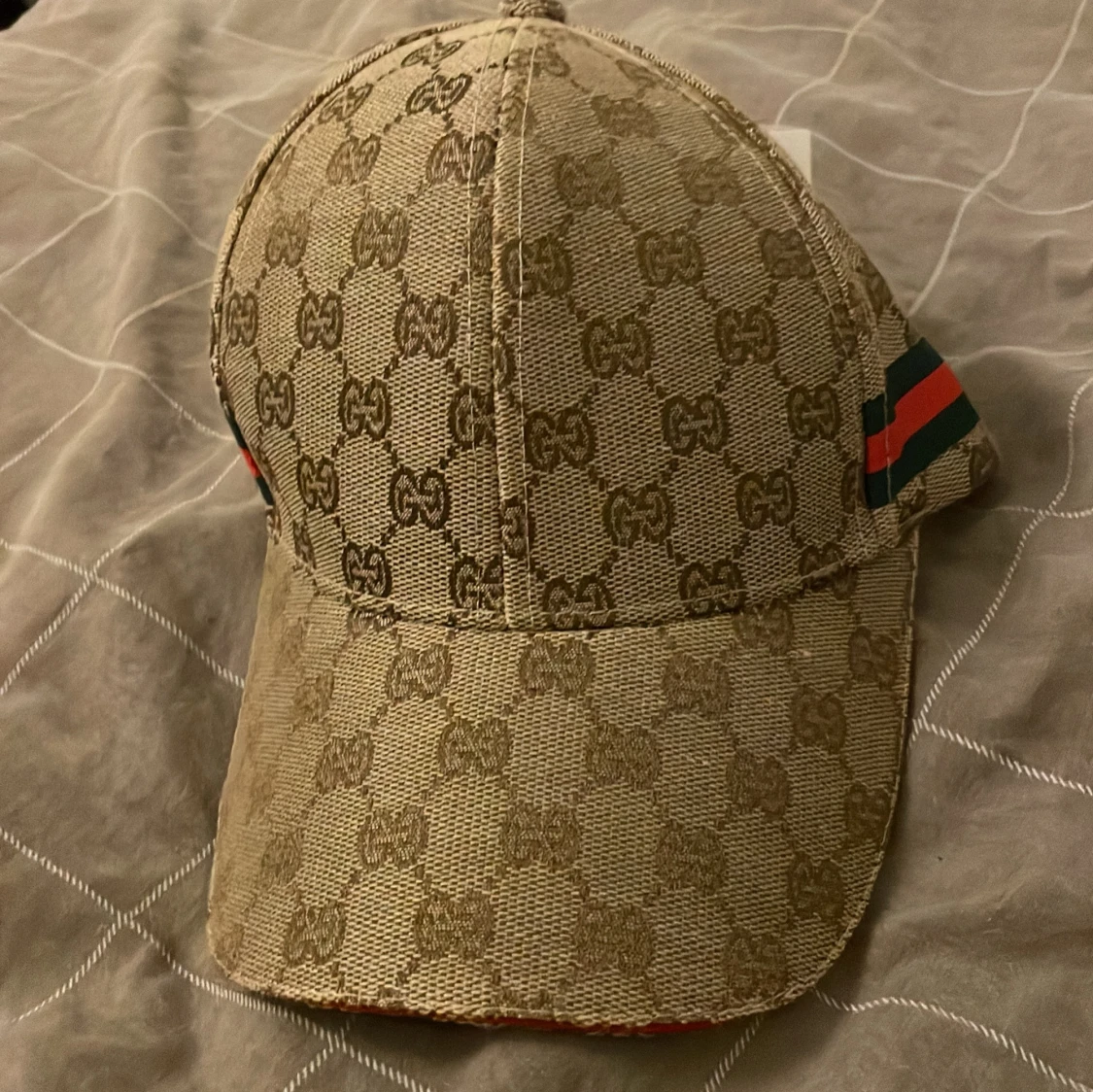 Beige keps med GG-mönster och ränder