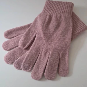 Ljusrosa stickade fingervantar - Mysiga stickade fingervantar i en ljusrosa nyans. Vantarna har ribbade muddar och är helt enfärgade utan mönster. Perfekta för kalla dagar när du vill hålla händerna varma och ändå kunna använda mobilen.