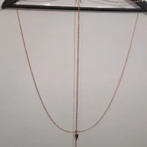 Guldfärgat kroppssmycke / Body Chain - Ett vackert och glänsande kroppssmycke i guldfärgad metall. Smycket består av flera tunna kedjor som pryder halsen och överkroppen. Det är en perfekt accessoar för att lyfta en outfit, och kan bäras över en bikini, en crop top eller en enkel klänning. Den bohemiska stilen gör den idealisk för fest och festival.  Har för mig att jag har köpt den på Bubbelroom eller Nelly.  Längd: 68 cm