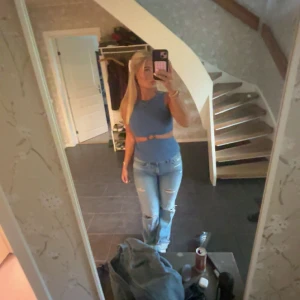 Blå croppad topp med ring från Zara - Säljer en blå croppad topp från Zara med ärmlös design och snygg cut-out detalj med ring framtill. Toppen har en stilren look och är tillverkad i ett mjukt polyestertyg. Perfekt för dig som vill sticka ut lite extra.