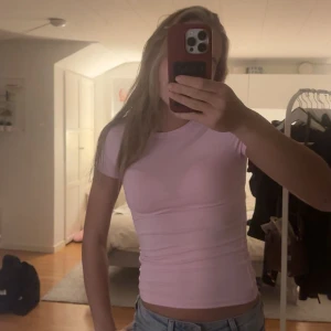 Ljusrosa tight topp från Gina Tricot - Säljer en ljusrosa topp från Gina Tricot med rund hals och korta ärmar. Modellen är tight och croppad, perfekt till jeans eller kjol. Materialet är mjuk bomull som sitter skönt mot kroppen. Enkel och fräsch design som är lätt att matcha. Från deras soft touch serie!💞