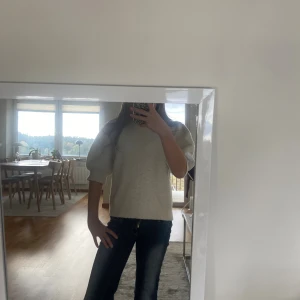 Vit stickad tröja med puffärm - Säljer en vit stickad tröja med puffiga trekvartsärmar och rund hals. Tröjan har en mjuk och lite fluffig struktur som gör den extra mysig. Passformen är normal och den är perfekt att matcha med jeans eller kjol för en chill look.