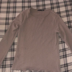 Beige strukturerad tröja med valongdetalj  - Supersöt och bekväm tröja från lager 157 i storlek S. Tyget har en bubblig/ strukturerad textur och en söt volangdetalj framtill som ger plagget det lilla extra. Med utsprungna armar på slutet. Använd 2-3 ggr. För att se den på skriv till mig!