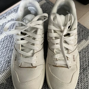 New Balance 560 sneakers med leoparddetalj - Snygga New Balance 560 sneakers i ljus beige med coola leopardmönstrade detaljer vid hälen. Skorna har snörning, platt sula i gummi och rund tå. Materialet är en mix av mocka och syntet, och sulan är i brunt gummi för extra street vibe.