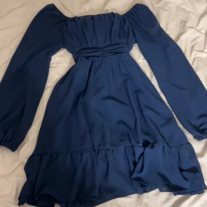 Marinblå klänning - Den är oanvänd och i bra kvalitet. Den har ganska puffiga armar, man kan ha den off the shoulder eller vanligt.