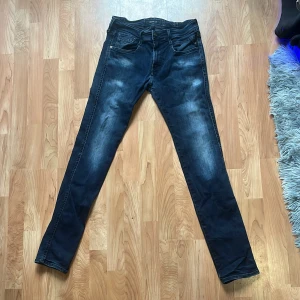Replay mörkblå jeans 30/32 - Snygga mörkblå jeans från Replay i klassisk femficksmodell. Jeansen har en slim passform med raka ben och subtila slitningar framtill för en cool look. Tillverkade i mjukt denimtyg som sitter skönt hela dagen.