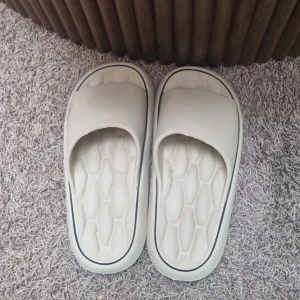 Vita chunky sandaler med platt sula - Säljer ett par vita chunky sandaler med platt sula och öppen tå. De har en bred rem över foten och en mönstrad innersula för extra komfort. Perfekta för sommaren och chill dagar hemma eller ute.