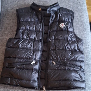 Äkta moncler väst  - Svart dunväst frän moncler i storlek S/2 hyfsat så använd, litet hål på baksidan syns knappt.  