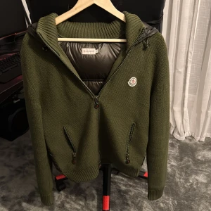  Moncler cardigan  - Tjena Säljer nu min grön cardigan från Moncler med stickade ärmar och framstycke, samt quiltad rygg och huva i blankt material. Jackan har två dragkedjeförsedda fickor, Moncler-logga på bröstet. Perfekt för de lite kyligare väder vid frågor är det bara att skriva pris kan diskuteras vid snabb affär 
