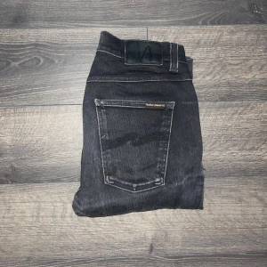 Nudie Jeans Lean Dean - Säljer ett par svarta herr  Nudie Jeans Lean Dean med klassisk femficksdesign och snygga kontrastsömmar. Jeansen har en smal passform. Midja 37,5 längd 106,5cm. Ifall det inte finns någon bild i annonsen där jag bär plagget så är det för att jag ej kan ha storleken heller passformen, så kolla måtten för storlek och googla på modellnamnet för passform 😉S3