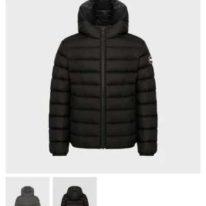 Svart dunjacka från Colmar - Säljer en svart dunjacka från Colmar med huva och klassisk logga på ärmen. Jackan har quiltad design, dragkedja framtill och två sidofickor. Perfekt för kalla dagar och har en snygg, stilren look.