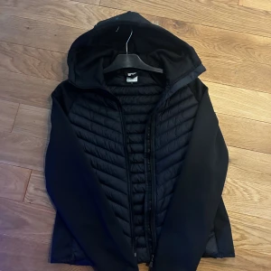 Svart pufferjacka från McKinley - Svart cardigan från McKinley. Jackan har andvänds en gång så den är som ny. Jackan har dragkedja och är långärmad med slät polyester på ärmarna och sidorna. 