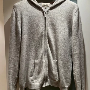 Grå zip  hoodie från Soft Goat - Mysig grå hoodie från Soft Goat med dragkedja och fickor i stl 170. Kashmir! 
