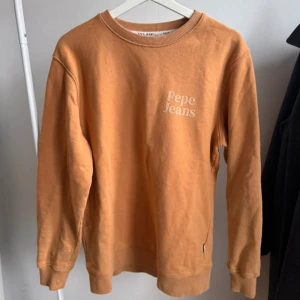Tröja från Pepe Jeans - Långärmad tröja från Pepe Jeans, storlek M i färgen mixing beige. Snygg orangebrun färg. Använd några men i fortsatt bra skick.