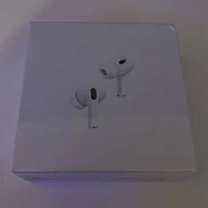 AirPods Pro (2nd generation) with MagSafe Charging Case (USB-C) - Nya och oöppnade Apple AirPods Pro (2nd generation) med MagSafe-laddningsetui (USB-C). Aktiv brusreducering, transparensläge och förbättrad batteritid. Perfekt för musik, samtal och träning. Kartongen är i fint skick utan synligt slitage.