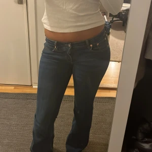 Utsvängda jeans  - Snygga blå jeans från Lager 157 med låg midja och klassisk bootcut-passform. Jeansen har fem fickor, knapp- och dragkedjestängning samt en mörkblå tvätt. Perfekta för dig som gillar en retro vibe och vill ha ett par jeans med lite utsvängda ben.