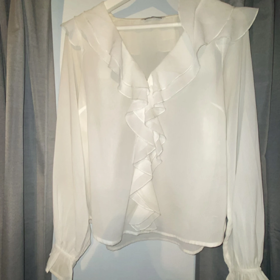 Vit blus med volang och lång ärmar