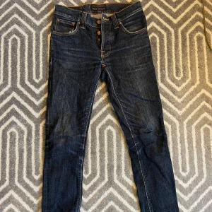 Nudie Jeans Grim Tim Dry Navy - Säljer ett par mörkblåa Nudie Jeans Grim Tim. Sköna och sitter snyggt. Har riktigt feta märken och blir bara snyggare desto mer man använder dem. Tveka inte på att skriva om du undrar nåt!✨