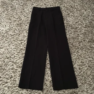 Svarta vida kostymbyxor - Jättesnygga svarta kostymbyxor med vida ben. Klassisk design med hällor för bälte och diskreta bakfickor. Perfekta för en clean och stilren look.💗