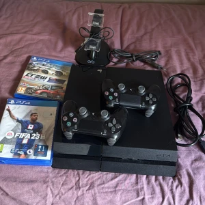 PlayStation 4 med spel och tillbehör - Konsolen är i bra skick. Sparsamt använt och funkar bra för sin ålder. 2 kontroller följer med samt laddare/hållare som laddar 2 kontroller åt gången. Ström kapell, hdmi och laddnings kampel följer även med. Fifa23 och the crew följer med gratis, har även Gta5 och fifa21 (ps4/ps5) som kostar 100/st. Obs! Hdmi intaget behöver bytas då den inte funkar alls