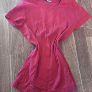 Röd t-shirt från Street One - Enkel och snygg röd t-shirt från Street One med rund halsringning och korta ärmar. T-shirten är i mjuk bomull och har en klassisk passform som funkar till det mesta. Perfekt för dig som gillar färg och vill ha en basic tee i garderoben.