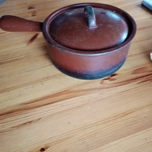 Liten Gjutjärnskastrull brun med lock  - Denna  gamla Gjutjärnskastrull brun med lock är väl använd och viss slitage finnes ,se bilder. Är märkt i botten 