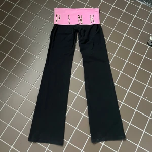 Svarta yoga pants från Victoria's Secret Pink - Svarta yoga pants från Victoria's Secret Pink med utsvängda ben och låg midja, storlek s enligt lapp. Innerbenslängd är 84 cm och midja rakt över är 37 cm. De har blivit något ”blekta” längst ner vid fållen och en liten bit av sömmen (se sista bilden) har blivit lite lös men det går absolut att sy om man vill det. I övrigt i superbra skick. Använd köp nu! 💗