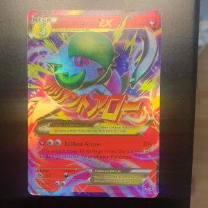 M Gardevoir EX, HP 210 - Coolt och färgstarkt Pokémonkort: M Gardevoir EX! Perfekt för samlare och fans av Pokémon TCG. Kortet har en glittrig design och är en Mega Evolution med attacken Brilliant Arrow. Ett måste för dig som älskar Pokémon och vill utöka din samling!
