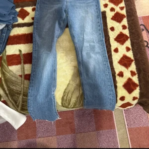 Ljusblå jeans från g perfect jeans, stl 34 - Ljusblå jeans från g perfect jeans i klassisk rak modell. Jeansen har hög midja, fem fickor och råa, fransiga benslut med slits. Tillverkade i robust denim med dragkedja och knapp framtill. Perfekta för en avslappnad och trendig look.