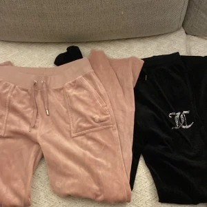 Juicy Couture mjukisbyxor rosa & svarta - Två par klassiska Juicy Couture mjukisbyxor i sammet, ett par i ljusrosa med snörning och fickor med lock bak, och ett par svarta med glittrig JC-logga framtill. Båda har resår i midjan och raka ben. Perfekta för en chill och trendig look. De svarta är i storlek 14/15 och rosa i M💕 Rosa saknar en  metall-plutt vid snöret och är avklippta men är i normal längd💕550kr/st
