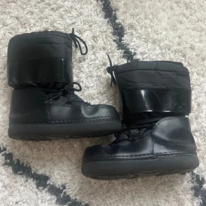 Svarta moon boots med snörning - Svarta snöskor från Duffy i storlek 37/38. Obs det är slitet vid hälen och hål rakt igenom vid hälen, de behöver repareras, därav priset <3