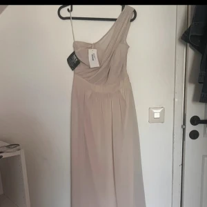 Balklänning/Brudtärna/lång klänning - En jätte fin klänning från Nelly som är helt ny med alla prislappar kvar. Bandet som sitter på klädhängaren på vänster sida är inte "en del" av klänningen utan klänningen är "one shoulder". Den är lång och passar perfekt till balen eller att ha på bröllop💞 Pris kan alltid diskuterad vid snabb affär!!!