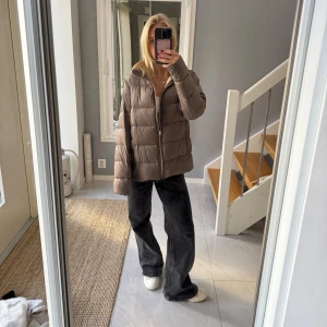 Beige pufferjacka med dragkedja - Säljer en beige pufferjacka med snygg quiltad design och guldfärgad dragkedja framtill. Jackan har en loose passform och är långärmad, perfekt för att hålla värmen under kyliga dagar. jackan har en stilren look som passar till många outfits.