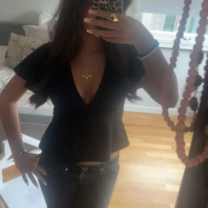 Svart v-ringad blus med volang - jätte snygg blus från gina som man kan knyta där bak!