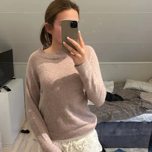Ljusrosa stickad tröja från Vero Moda - Mysig ljusrosa stickad tröja från Vero Moda i storlek S. Tröjan har rund halsringning, långa ärmar och ribbade muddar vid ärmslut och nederkant. Perfekt för lager-på-lager och chill dagar.