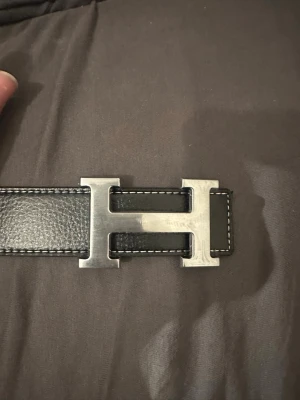 Bälte med H-format spänne – no brand - ✨ Nytt bälte! ✨ 	•	Längd: 110 cm 	•	Finns i vitt & svart ⚪⚫ 	•	Stilrent och praktiskt för alla tillfällen 👌  💖 Köp fler – spara mer! 	•	2 stycken eller fler → rabatt gäller! 🎉