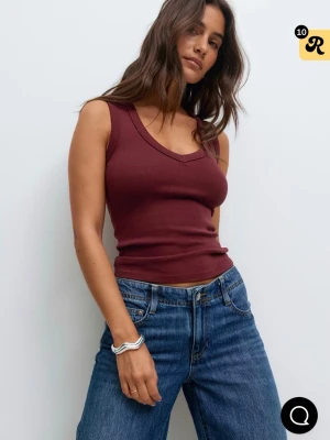 Vinröd ribbad linnetopp - Snygg vinröd linnetopp med v-ringning och ribbad struktur. Toppen är ärmlös och har en figurnära passform som sitter skönt mot kroppen. Perfekt att styla med jeans eller kjol för en enkel och trendig look.