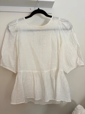 Vit volang blus - Vit volang blus från hm i storlek S! Har en liten defekt som syns på andra bilden, men detta lägger man inte märke till