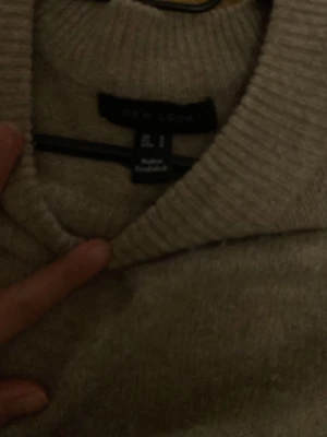 Beige stickad tröja från New Look - Mysig beige stickad tröja från New Look i storlek L. Tröjan har rund halsringning, ribbade muddar och en relaxed passform. Perfekt för lager på lager under höst och vinter. Enkel och stilren design som är lätt att matcha.