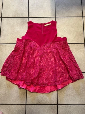 Rosa spetsblus från MATA storlek XXL - Säljer en riktigt snygg rosa blus från MATA med spetsdetaljer och lätt utsvängd passform. Toppen är ärmlös och har dragkedja i ryggen. Perfekt för dig som gillar feminina detaljer och vill sticka ut lite extra.