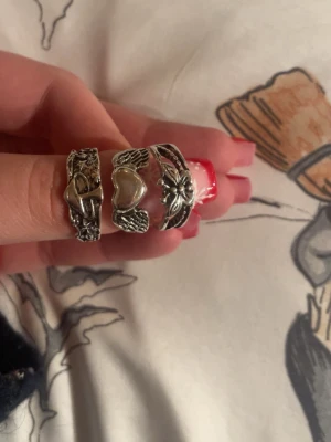 Ringar - 6st silver ringar, helt onanvända! Den första bilden ringen längst åt vänster är storlek ungefär 21mm och dom två åt höger ungefär 19,5mm. Bild två är alla ringar justerbara (se bild tre) pris kan diskuteras!! Priset nu är för alla 6 ringar! Skriv om frågor! 