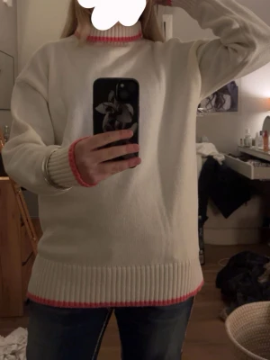 Vit oanvänd stickad tröja från Weel Me There med lappar kvar xxs/xs - Säljer en vit stickad tröja från Meet Me There med rosa detaljer vid hals, ärmslut och nederkant. Tröjan har lång ärm, ribbade muddar och en liten slits på sidorna. Perfekt för dig som gillar en clean look med en färgklick. Helt nytt skick med lappar kvar!