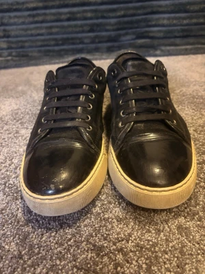 Lanvins svarta - Säljer ett par svarta Lanvins med ovandel i både skinn och mocka, samt vita sulor för en clean kontrast. Perfekta nu till vintern även perfekta till jeans eller chinos för en avslappnad look. Priset är inte spickat