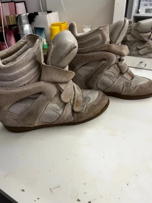 Beige Isabel Marant sneakers med kilklack - Säljer ett par beige sneakers från Isabel Marant. Skorna är väldigt använda som syns på bilden och har ingen sula därav billigt pris men kan sänka vid snabb affär 💗