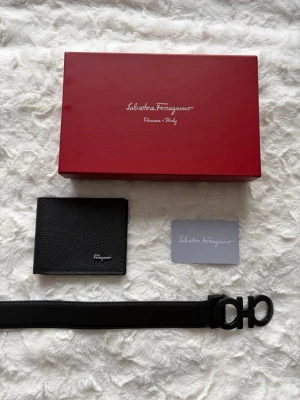 Ferragamo bälte och plånbok set - Hel svart Ferragamo Salvatore set som består av ett bälte och en matchande plånbok. Ingen användning på båda varorna. 110cm lång 