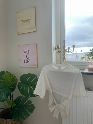 Nelly open back Tie Tee  - Jättefin Tie Tee från Nelly, nästan aldrig använd för den va inte för mig 💞 Storlek XS, har också fått lite smink på halsen men tror det går bort i tvätt