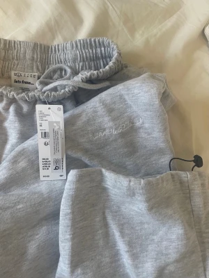 Grå mjukisbyxor från Iets Frans - Säljer ett par ljusgrå mjukisbyxor från iets frans modellen Grey Harri Baggy Joggers. Byxorna har resår och snörning i midjan samt en bakficka. De är loose fit, storlek xs. De var tyvärr en storlek försmå för mig och därför säljer jag. Helt nya, lappen är kvar.