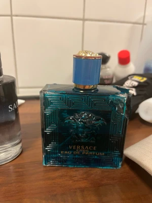 Versace Eros Eau de Parfum - Versace Eros Eau de Parfum med ikonisk design och lyxig känsla. Perfekt för dig som vill sticka ut och visa din personlighet. Flaskan har en unik blå färg och Medusa-detalj som ger extra attityd.