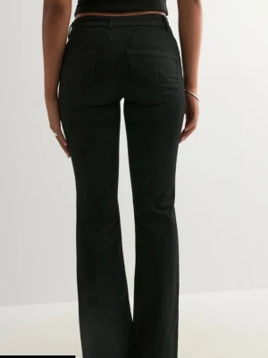 Lågmidjade svarta jeans från Nelly - Säljer mina svarta low waist bootcut jeans från Nelly då dem inte kommer till användning. Jättefint skick och slutsålda. Kom gärna med prisförslag. Nypris 700kr.